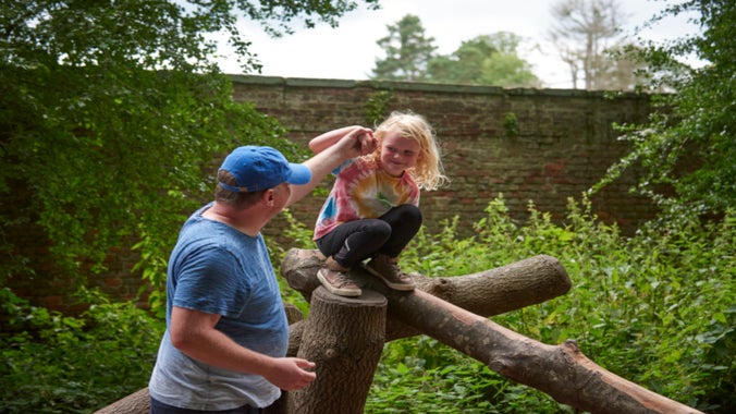 Families exploring Wolf’s Den natural play area at Erddig